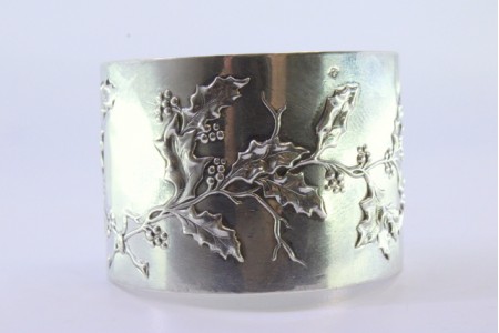 Argola de guardanapo em prata com motivos florais relevados e envolvendo cartela para monograma.